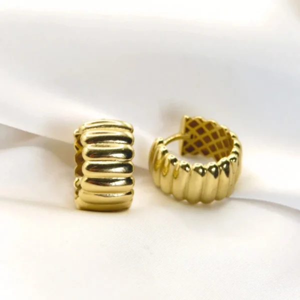 Arracadas de oro con diseño “camino”, caracterizados por su textura acanalada. Joyería fina de Mena.