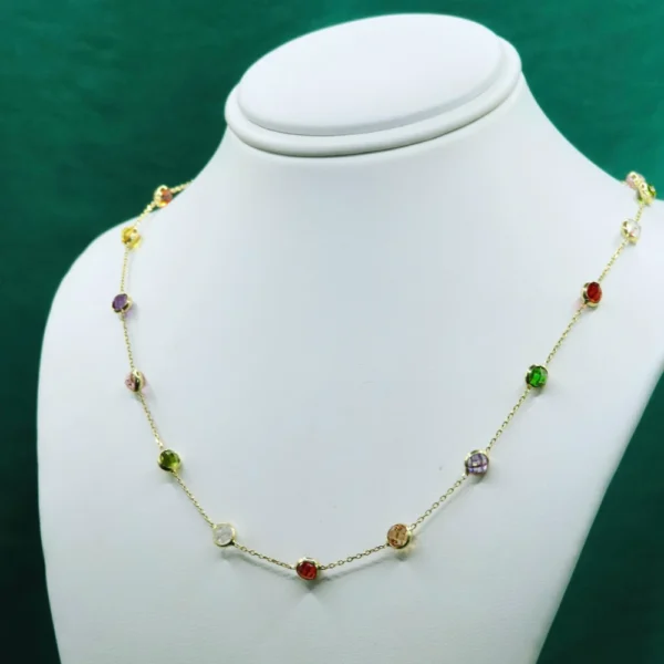 Delicada gargantilla en oro adornada con piedras multicolor engastadas a lo largo de una fina cadena. Joyería fina de Mena.