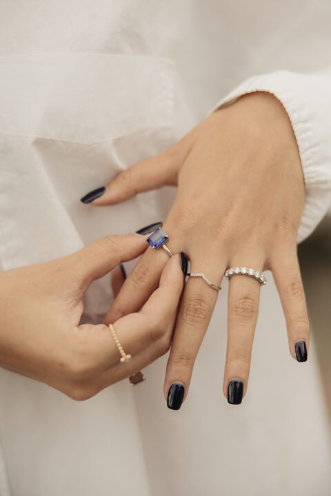 Primer plano de ambas manos de una modelo con anillos de diferentes modelos. Diseños exclusivos de Mena Fine Jewelry.